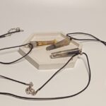 Кулон с окурком: загадочный аксессуар с характером Представляем вам необычный кулон, который сочетает в себе минимализм и дерзкий шарм. Изделие выполнено в виде удлинённого прозрачного кристалла, внутри которого заключён миниатюрный окурок — словно застывший фрагмент повседневности, превращённый в произведение искусства. Особенности кулона: * Материал: прозрачная смола или акрил, надёжно сохраняющая «секрет» внутри. * Дизайн: лаконичная форма с заострённым концом придаёт украшению современный вид. * Шнурок: прочный чёрный шнур с металлической застёжкой — универсальный вариант, который подойдёт к любой одежде. * Размер: компактный, не отвлекает от образа, но при этом заметен при ближайшем рассмотрении. Почему этот кулон стоит внимания? * Уникальный дизайн. Такой аксессуар точно выделит вас из толпы и станет поводом для интересных бесед. * Символика. Окурок в кулоне может восприниматься как ироничный символ свободы, непринуждённости или даже философии «живи настоящим моментом». * Универсальность. Подходит как мужчинам, так и женщинам — идеален для поклонников альтернативной моды, рок-стиля или кэжуал-образов. * Лёгкость в уходе. Прозрачный материал легко очищается, а шнур устойчив к износу. Этот кулон — не просто украшение, а смелое заявление о вашем чувстве юмора и индивидуальности. Носите его с джинсами и футболкой, кожаной курткой или даже с классическим пальто — он добавит образу изюминку и характер.