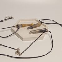 Кулон с окурком: загадочный аксессуар с характером Представляем вам необычный кулон, который сочетает в себе минимализм и дерзкий шарм. Изделие выполнено в виде удлинённого прозрачного кристалла, внутри которого заключён миниатюрный окурок — словно застывший фрагмент повседневности, превращённый в произведение искусства. Особенности кулона: * Материал: прозрачная смола или акрил, надёжно сохраняющая «секрет» внутри. * Дизайн: лаконичная форма с заострённым концом придаёт украшению современный вид. * Шнурок: прочный чёрный шнур с металлической застёжкой — универсальный вариант, который подойдёт к любой одежде. * Размер: компактный, не отвлекает от образа, но при этом заметен при ближайшем рассмотрении. Почему этот кулон стоит внимания? * Уникальный дизайн. Такой аксессуар точно выделит вас из толпы и станет поводом для интересных бесед. * Символика. Окурок в кулоне может восприниматься как ироничный символ свободы, непринуждённости или даже философии «живи настоящим моментом». * Универсальность. Подходит как мужчинам, так и женщинам — идеален для поклонников альтернативной моды, рок-стиля или кэжуал-образов. * Лёгкость в уходе. Прозрачный материал легко очищается, а шнур устойчив к износу. Этот кулон — не просто украшение, а смелое заявление о вашем чувстве юмора и индивидуальности. Носите его с джинсами и футболкой, кожаной курткой или даже с классическим пальто — он добавит образу изюминку и характер.