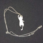 В таинственных землях Эльдариона, где магия сплетается с реальностью, был создан этот волшебный кулон в виде игривого кота. Словно сотканный из лунного света и осколков звёздного неба, он покоится на изящной серебряной цепочке, которая переливается, будто сотканная из нитей древней магии. Кот на подвеске — не просто украшение, а хранитель маленьких секретов. Его полупрозрачная фигура, созданная из эпоксидной смолы, словно застыла в прыжке, а на шерсти мерцает узор, напоминающий лепестки зачарованного цветка. Говорят, что этот узор способен менять оттенки в зависимости от настроения владельца: становится нежно-голубым, когда сердце наполнено радостью, или глубоким фиолетовым, если душа тоскует. Легенда гласит, что этот кот — дух-хранитель, призванный оберегать своего владельца от бед и невзгод. В полнолуние он оживает на мгновение, чтобы прошептать на ухо своему хозяину древние истины или предупредить о грядущей опасности. Его хвост — это нить судьбы, связывающая владельца с магией мира, а глаза хранят в себе силу видеть то, что скрыто от обычного взгляда. Этот кулон — не просто аксессуар, а талисман, который принесёт удачу, защитит от злых чар и подарит своему владельцу частичку волшебства Эльдариона. Носите его с гордостью, и пусть магия сопровождает вас во всех приключениях!