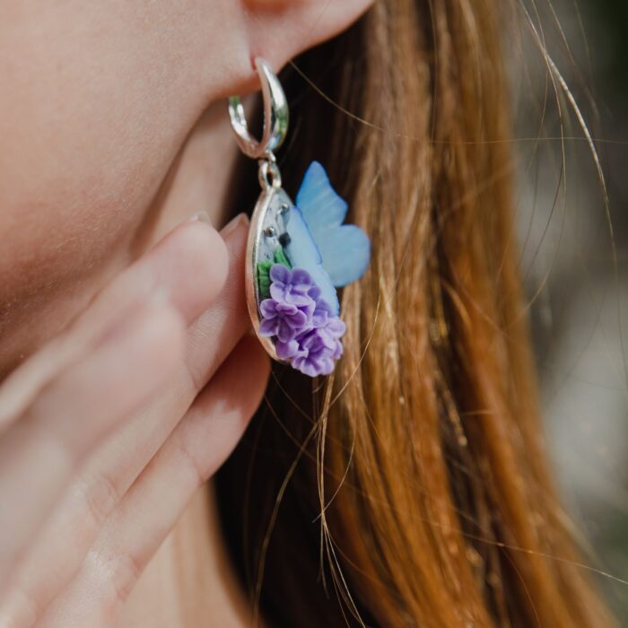 Серьги с голубыми бабочками и сиренью Изящное украшение, воплощающее хрупкую красоту весенней природы. Каждая пара серёг создана вручную из полимерной глины — с трепетным вниманием к деталям и любовью к природному совершенству.