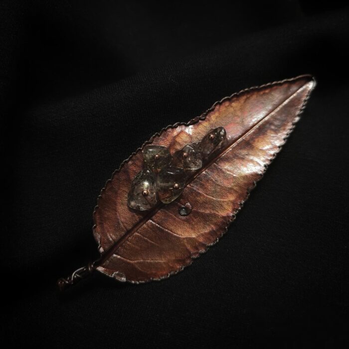 Эта изысканная брошь в виде листа миндаля - настоящий шедевр природного искусства. Сотканная из осеннего уюта и магии металла, она словно живой лист, хранящий в себе секреты древних лесов.