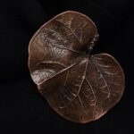 Изящная мини-брошь в виде листа скумпии, словно застывшего в металле воспоминания о крымских пейзажах. Выполненная в технике гальванопластика, она поражает точностью передачи мельчайших фактурных прожилок, которые создают завораживающий узор, похожий на тончайшее кружево.