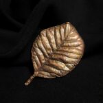 Эта изысканная брошь в форме листа скумпии, словно сошедшая со страниц волшебной сказки, станет прекрасным дополнением к любому наряду. Техника гальванопластики позволила с поразительной точностью передать каждую прожилку, сохранив природную изящность контура.