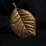 Эта изысканная брошь в форме листа скумпии, словно сошедшая со страниц волшебной сказки, станет прекрасным дополнением к любому наряду. Техника гальванопластики позволила с поразительной точностью передать каждую прожилку, сохранив природную изящность контура.