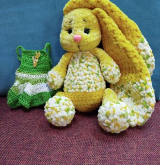 Представляем очаровательную вязаную зайку, выполненную из мягкой плюшевой пряжи. Игрушка выглядит очень уютно и привлекательно — идеальный вариант для подарка ребёнку или украшения интерьера. Материал: плюшевая пряжа, приятная на ощупь, гиппоаллергенная. Цвет: основной цвет игрушки — солнечно-жёлтый с вкраплениями белого и светло-зелёного, создающими эффект «цветочного» узора. Дизайн: длинные мягкие ушки, придающие зайке особый шарм; Выразительные глазки на безопасном креплении; милый розовый носик; аккуратные лапки и туловище с объёмной текстурой. Комплектация: сама зайка; вязаное платье зелёного цвета с белым; Платье украшено декоративной брошкой в виде зайчика, что добавляет изделию индивидуальности. Инструкция-рекомендация по уходу. Подарочная упаковка(на Ваш выбор,по согласованию). Размер: компактный, удобно держать в руках (точный размер зависит от конкретной вязки,толщины и метража нити). Безопасность: Глаза и носик на безопасном креплении,с дополнительной фиксацией(запаяны).Лапки и ушки ввязаны в изделие.Игрушка безопасна для детей. Преимущества: ручная работа — каждая игрушка уникальна;экологичные и безопасные материалы;универсальность: подойдёт как для игр, так и для коллекционирования.Эта зайка станет любимым другом ребёнка или милым сувениром для близких. Подарите тепло и уют с этой очаровательной игрушкой. Возможно изготовление под Ваши пожелания в другом цвете,комплектации аксессуаров. Всегда рады помочь Вам с выбором. С любовью и теплом для Вас Вязаные прелести.