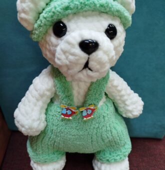 Игрушка связана с любовью в каждой петельке. Мягкая и нежная в объятьях ваших рук. Очаровательный вязаный мишка амигуруми — идеальный подарок для ребёнка или украшение интерьера. Игрушка выполнена вручную из мягкой плюшевой пряжи, которая приятна на ощупь и абсолютно безопасна для малышей. Особенности: Материал: высококачественная плюшевая пряжа, гипоаллергенная, не вызывает раздражения. Дизайн: мишка одет в уютный зелёный комбинезон и шапочку в тон, украшенные милыми декоративными элементами в виде вертолётиков. Детализация: выразительные чёрные глазки придают игрушке живой и дружелюбный вид; аккуратный носик выполнен из безопасного материала. Наполнитель: холлофайбер, который обеспечивает мягкость и сохраняет форму игрушки. Размер: компактный, удобно держать в руках. 36 см. Безопасность: все элементы надёжно закреплены, отсутствуют мелкие съёмные детали, которые могут представлять опасность для ребёнка. Для кого подойдёт: в качестве подарка ребёнку на день рождения, Новый год или другой праздник; как милый сувенир для близких; для украшения детской комнаты или рабочего стола; для коллекционеров вязаных игрушек. Преимущества: ручная работа — каждая игрушка уникальна; экологичные и безопасные материалы; долговечность: игрушка не теряет форму и цвет при бережном использовании; стильный дизайн с милыми деталями. Подарите себе или близким немного тепла и уюта с этим очаровательным вязаным мишкой! Возможно изготовление под Ваши пожелания в другом цвете,комплектации аксессуаров. Всегда рады помочь Вам с выбором. С любовью и теплом для Вас Вязаные прелести.