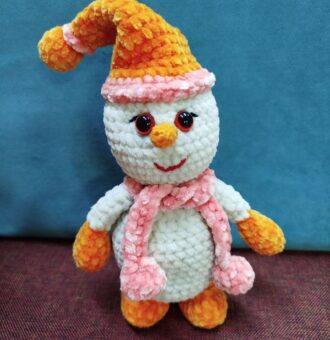 Описание товара: вязаный плюшевый снеговик амигуруми Подарите себе или близким частичку зимней сказки с этим очаровательным вязаным снеговиком, выполненным в технике амигуруми! Ручная работа и внимание к деталям делают эту игрушку по-настоящему уникальной. Особенности: Материал: мягкая плюшевая пряжа, приятная на ощупь, гипоаллергенная. Дизайн: белоснежное туловище и голова создают образ классического снеговика; яркий оранжевый колпак с розовой окантовкой добавляет игривости; морковный нос оранжевого цвета — узнаваемый элемент образа; выразительные глазки с блеском, создающие «живой» взгляд; весёлая красная улыбка придаёт игрушке дружелюбный вид; розовый шарф с объёмными помпонами — стильный акцент; оранжевые «рукавички» и «сапожки» гармонично дополняют образ. Размер: компактный, удобно держать в руках (точный размер уточняйте при заказе). Наполнитель: безопасный синтепух, обеспечивающий мягкость и упругость. Безопасность: все элементы надёжно закреплены, изделие абсолютно безопасно для детей. Преимущества: Ручная работа: каждая игрушка уникальна, с небольшими отличиями в деталях вязки. Экологичные материалы: не вызывают аллергии, подходят даже для самых маленьких. Долговечность: пряжа устойчива к износу, игрушка сохраняет форму и цвет долгое время. Универсальность: подойдёт как для игр, так и для украшения интерьера в зимний период или на Новый год. Яркий дизайн: поднимет настроение и станет любимым другом ребёнка или милым сувениром для взрослых. Рекомендации по уходу: бережная ручная стирка в прохладной воде; избегать использования агрессивных моющих средств; сушить в расправленном виде вдали от прямых солнечных лучей. Этот вязаный снеговик принесёт в дом атмосферу уюта и праздника. Отличный выбор для подарка на Новый год, Рождество или просто для создания зимнего настроения!