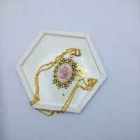 Кулон «Шепот древних садов» — амулет эльфийских лесов Перед вами не просто украшение, а магический артефакт, рождённый на стыке реальности и чар. Этот кулон — словно осколок зачарованного сада, где цветы никогда не увядают, а лепестки хранят память о древних заклинаниях. Овальный медальон обрамлён изысканной золотой оправой, украшенной миниатюрными цветочными узорами. Говорят, эти узоры выгравированы не рукой мастера, а самой природой — будто лесные духи шепнули металлу свой тайный орнамент. В центре кулона — загадочный состав,на котором застыл нежный розовый цветок, заключённый в прозрачную смолу. Это не просто растение — это «сердце леса», впитавшее силу тысячелетних деревьев и энергию утренней росы. Легенда гласит, что каждый лепесток хранит одно древнее пророчество. Металлическая цепочка под золото, на которой держится амулет, будто сплетена из солнечных лучей. Она не только украшает, но и служит проводником магии: связывает владельца с природой, помогает слышать шёпот ветра и понимать язык цветов. Считается, что кулон «Шепот древних садов» обладает особыми свойствами: * защищает от тёмной магии и злых чар; * приносит гармонию и умиротворение, помогая найти баланс между внутренним миром и реальностью; * открывает сердце для вдохновения — достаточно взглянуть на него, чтобы почувствовать прилив творческих сил; * служит талисманом для путешественников, оберегая в пути и подсказывая верный маршрут. Носите этот кулон как символ связи с волшебным миром природы. Пусть он станет вашим личным оберегом, хранителем тайн и источником силы в каждом дне. Откройте дверь в сказку — она ближе, чем кажется!