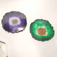 Подставки-жеоды: осколки древних миров в вашем доме Перед вами — не просто подставки под чашки, а фрагменты магических кристаллов, извлечённых из недр зачарованных земель. Словно срезы древних жеод, они хранят в себе энергию стихий и шёпот забытых заклинаний. Фиолетовая жеода: * окутана аурой мистической ночи; * мерцает, будто звёздное небо в полнолуние; * серебристое ядро в центре — это запечатанный портал в иные измерения; * её энергия помогает сосредоточиться и найти ответы на самые сложные вопросы. Зелёная жеода с золотым сердцем: * наполнена силой природы и древних лесов; * зелёный оттенок напоминает о магии друидов и целебных травах; * золотое ядро — словно солнце, заключённое в камне, приносит удачу и процветание; * создаёт атмосферу гармонии и умиротворения. Эти артефакты созданы из особой смолы, пропитанной эссенцией лунного света и солнечных лучей. Их неровные края — не случайность, а отпечаток прикосновения древних духов-хранителей. Почему эти подставки особенные? * Магическая эстетика: превратят любую сервировку в сцену из фэнтези-романа. * Практичность: защитят стол от горячих чашек и случайных царапин. * Уникальность: каждая подставка неповторима, как отпечаток пальца мага. * Энергетика: по легенде, такие жеоды усиливают интуицию и открывают каналы для вдохновения. Позвольте этим осколкам волшебства стать частью вашего быта. Пусть каждый глоток чая или кофе будет сопровождаться ощущением прикосновения к тайнам вселенной!