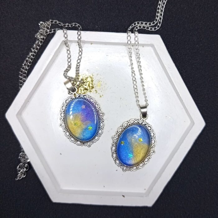 Кулоны «Звёздный шёпот» — эхо древних созвездий Перед вами не просто украшения, а магические реликвии, рождённые на стыке реальности и волшебства. Эти кулоны словно хранят в себе отблески далёких галактик, где звёзды сплетают свои истории в танце вечности. Каждый кулон обрамлён изящной металлической оправой в цвете серебра, напоминающей древние эльфийские узоры — будто искусные мастера зачаровали металл, чтобы он навеки хранил тайну небес. В центре — переливающийся состав, сотканный из оттенков ночного неба: глубокий синий плавно переходит в золотисто-жёлтый, словно рассвет, пробивающийся сквозь звёздную пыль. Маленькие искорки-звёзды, вкраплённые в состав, будто застыли в мгновении волшебства. Говорят, что каждая из них — это душа упавшей звезды, заключённая в амулет для защиты владельца. Эти звёзды шепчут древние заклинания, оберегая от бед и наполняя сердце вдохновением. Легенда гласит: тот, кто носит такой кулон, может услышать шёпот созвездий в тишине ночи. Они расскажут о забытых мирах, древних пророчествах и тайных тропах между измерениями. А если загадать желание под полной луной, держа кулон в ладони, оно непременно сбудется — ведь магия звёзд не знает преград. Позвольте этим кулонам стать вашими верными спутниками в путешествии по миру грёз и приключений. Они не просто украсят ваш образ — они станут частью вашей истории, наполняя каждый день магией и загадкой.