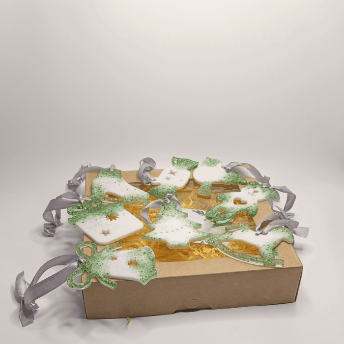 На изображении представлен набор елочных игрушек. Эти украшения словно сошли со страниц волшебной сказки. Каждая игрушка — это миниатюрное произведение искусства, созданное из эпоксидной смолы что делает их легкими, прочными и долговечными, и переливается на свету, как звездная пыль.