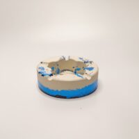 Пепельница-артефакт из зачарованного гипса: осколок древних рун Перед вами не просто пепельница, а древний артефакт, пробуждённый мастерами из забытых земель. Этот магический предмет словно вырван из страниц старинного гримуара — его форма хранит в себе печать древних заклинаний, а сине-белая гамма напоминает о небесных вратах, через которые некогда спускались духи стихий. Особенности «осколка рун»: * Материал: прочный гипс, пропитанный защитными чарами (устойчив к жару и времени). * Дизайн: углубления в центре — это не просто выемки, а рунические символы, сдерживающие энергию огня. Говорят, что если долго смотреть на них, можно увидеть мерцание искр. * Цветовая гамма: сочетание белоснежного фона и глубоких синих мазков создаёт иллюзию магического свечения. Это не случайный узор — так проявляется сила элементалей, заключённых в гипсе. * Форма: круглая основа символизирует защиту, а внутренние линии — потоки энергии, которые не дают злу проникнуть в ваш дом. Легенда: По преданию, такие пепельницы использовали хранители порталов между мирами. Они клали в них тлеющие угли ритуальных костров, чтобы сдерживать прорывы теней из нижних планов. Сегодня этот артефакт станет не только практичным предметом, но и оберегом для вашего жилища. Почему этот предмет уникален? * Эстетика: превратит любой интерьер в уголок волшебного замка. * Практичность: прочная конструкция выдержит даже самый жаркий пепел. * Энергетика: по легенде, поглощает негативные эмоции, оставляя лишь спокойствие и прохладу. * Эксклюзивность: каждый экземпляр обладает неповторимым узором — как отпечаток драконьей чешуи. Позвольте этому магическому артефакту стать частью вашего быта. Пусть каждая тлеющая сигарета превращается в крошечный ритуал, а ваш дом наполняется атмосферой древних легенд!