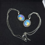 Кулоны «Звёздный шёпот» — эхо древних созвездий Перед вами не просто украшения, а магические реликвии, рождённые на стыке реальности и волшебства. Эти кулоны словно хранят в себе отблески далёких галактик, где звёзды сплетают свои истории в танце вечности. Каждый кулон обрамлён изящной металлической оправой в цвете серебра, напоминающей древние эльфийские узоры — будто искусные мастера зачаровали металл, чтобы он навеки хранил тайну небес. В центре — переливающийся состав, сотканный из оттенков ночного неба: глубокий синий плавно переходит в золотисто-жёлтый, словно рассвет, пробивающийся сквозь звёздную пыль. Маленькие искорки-звёзды, вкраплённые в состав, будто застыли в мгновении волшебства. Говорят, что каждая из них — это душа упавшей звезды, заключённая в амулет для защиты владельца. Эти звёзды шепчут древние заклинания, оберегая от бед и наполняя сердце вдохновением. Легенда гласит: тот, кто носит такой кулон, может услышать шёпот созвездий в тишине ночи. Они расскажут о забытых мирах, древних пророчествах и тайных тропах между измерениями. А если загадать желание под полной луной, держа кулон в ладони, оно непременно сбудется — ведь магия звёзд не знает преград. Позвольте этим кулонам стать вашими верными спутниками в путешествии по миру грёз и приключений. Они не просто украсят ваш образ — они станут частью вашей истории, наполняя каждый день магией и загадкой.