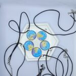 Кулон «Звёздная галактика» Этот кулон — не просто украшение, а настоящий портал в мир магии и звёздных тайн. Его подвески, словно кусочки ночного неба, переливаются оттенками синего, золотого и фиолетового, напоминая о далёких галактиках и сиянии луны. Каждая подвеска — это миниатюрная вселенная, полная загадок и волшебства. Подвески на металической основе изготовлены из прочной эпоксидной смолы, а шнурки — из качественного материала, обеспечивающего комфорт при ношении.