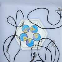 Кулон «Звёздная галактика» Этот кулон — не просто украшение, а настоящий портал в мир магии и звёздных тайн. Его подвески, словно кусочки ночного неба, переливаются оттенками синего, золотого и фиолетового, напоминая о далёких галактиках и сиянии луны. Каждая подвеска — это миниатюрная вселенная, полная загадок и волшебства. Подвески на металической основе изготовлены из прочной эпоксидной смолы, а шнурки — из качественного материала, обеспечивающего комфорт при ношении.