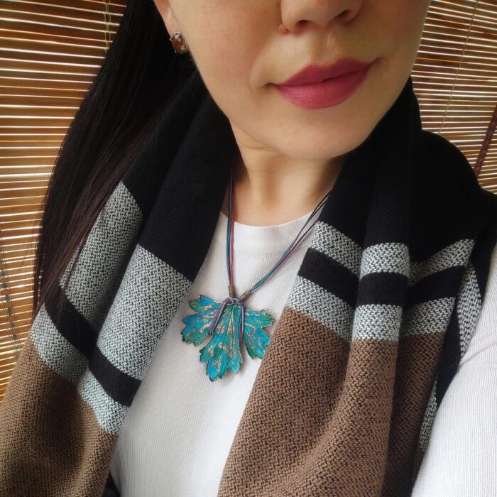 Изумительное колье, центральным элементом которого служит лист смородины, выполненный с помощью техники гальванопластика. Этот лист — не просто украшение, а маленькое произведение искусства: с одной стороны он играет зелёно-синими оттенками, словно отражая прохладу утренней росы, а с другой переливается нежно-зелёными и бирюзовыми тонами, напоминая о безмятежности летнего дня.