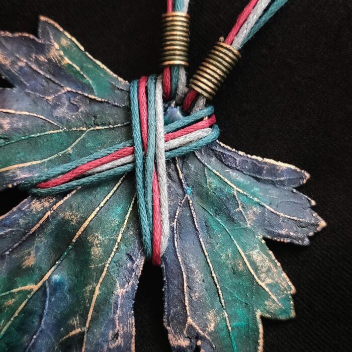 Изумительное колье, центральным элементом которого служит лист смородины, выполненный с помощью техники гальванопластика. Этот лист — не просто украшение, а маленькое произведение искусства: с одной стороны он играет зелёно-синими оттенками, словно отражая прохладу утренней росы, а с другой переливается нежно-зелёными и бирюзовыми тонами, напоминая о безмятежности летнего дня.