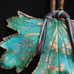 Изумительное колье, центральным элементом которого служит лист смородины, выполненный с помощью техники гальванопластика. Этот лист — не просто украшение, а маленькое произведение искусства: с одной стороны он играет зелёно-синими оттенками, словно отражая прохладу утренней росы, а с другой переливается нежно-зелёными и бирюзовыми тонами, напоминая о безмятежности летнего дня.