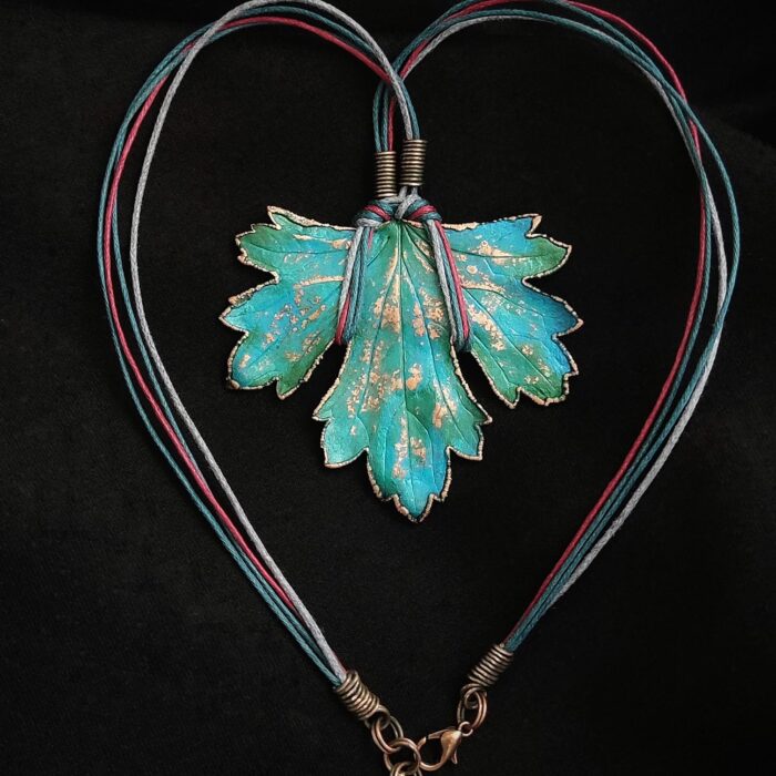 Изумительное колье, центральным элементом которого служит лист смородины, выполненный с помощью техники гальванопластика. Этот лист — не просто украшение, а маленькое произведение искусства: с одной стороны он играет зелёно-синими оттенками, словно отражая прохладу утренней росы, а с другой переливается нежно-зелёными и бирюзовыми тонами, напоминая о безмятежности летнего дня.