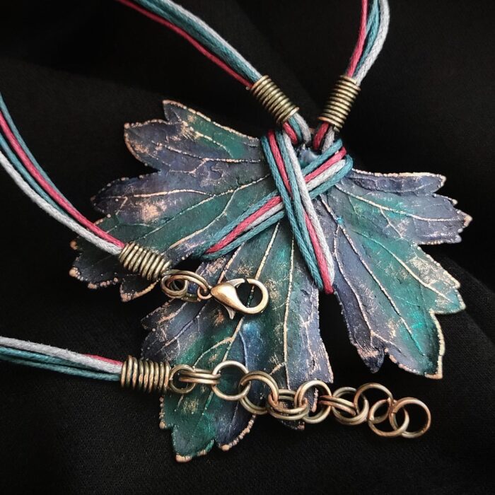 Изумительное колье, центральным элементом которого служит лист смородины, выполненный с помощью техники гальванопластика. Этот лист — не просто украшение, а маленькое произведение искусства: с одной стороны он играет зелёно-синими оттенками, словно отражая прохладу утренней росы, а с другой переливается нежно-зелёными и бирюзовыми тонами, напоминая о безмятежности летнего дня.
