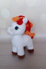 Вязаная игрушка — очаровательная лошадка, выполненная в технике амигуруми из мягкой гипоалергенной плюшевой пряжи.