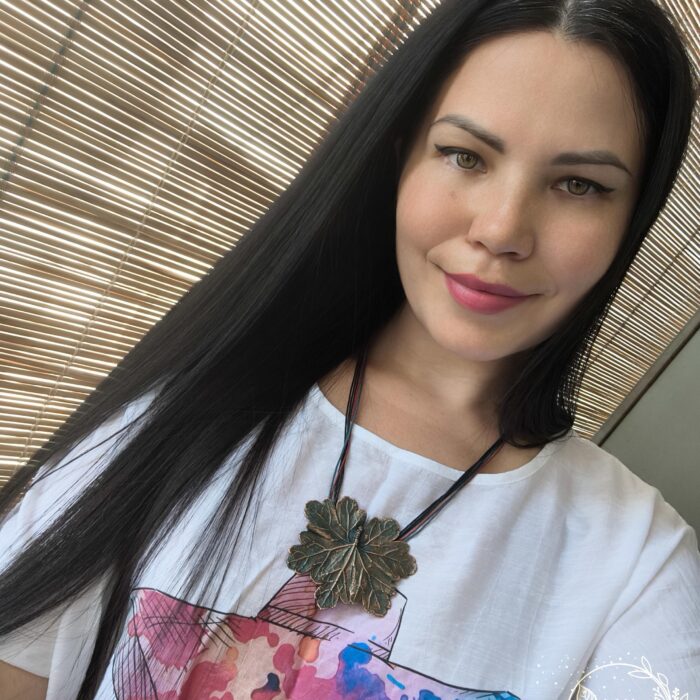 Изысканное колье, центральным элементом которого служит лист садовой герани, выполненный с помощью техники гальванопластика. Лист, окрашенный в нежные оттенки оливкового и болотно-бирюзового, словно парит в воздухе — вощёный шнур искусно выходит из его боковинок, создавая иллюзию невесомости и лёгкого парения.