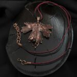 Это изысканное колье, созданное в технике гальванопластика, представляет собой реалистичный лист куста Смородины. Тонкий вощёный шнур подчеркивает природную красоту изделия.