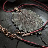 Изысканное колье, центральным элементом которого служит лист куста Яснотки, выполненный в технике гальванопластика. Поверхность листа переливается оттенками коричневого, медного и тёмно-шоколадного, а сияющая патина в зелёных тонах придаёт украшению загадочность и глубину.