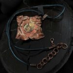 Уникальное колье, выполненное в технике гальванопластика — его центральным элементом стал хвостик от хурмы, превращённый в произведение искусства. Тёплые оттенки коричневого, медного и шоколадного окутывают подвеску, создавая ощущение природной гармонии и уюта.