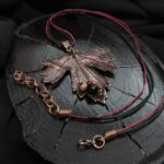 Это изысканное колье, созданное в технике гальванопластика, представляет собой реалистичный лист куста Смородины. Тонкий вощёный шнур подчеркивает природную красоту изделия.