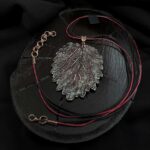 Изысканное колье, центральным элементом которого служит лист куста Яснотки, выполненный в технике гальванопластика. Поверхность листа переливается оттенками коричневого, медного и тёмно-шоколадного, а сияющая патина в зелёных тонах придаёт украшению загадочность и глубину.