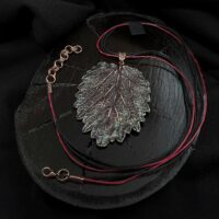 Изысканное колье, центральным элементом которого служит лист куста Яснотки, выполненный в технике гальванопластика. Поверхность листа переливается оттенками коричневого, медного и тёмно-шоколадного, а сияющая патина в зелёных тонах придаёт украшению загадочность и глубину.