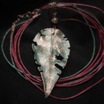 Завораживающее колье, в центре которого — подвеска в виде листа сирени, созданная с помощью техники гальванопластика. Лист словно хранит в себе историю: фактурные прожилки рассказывают о его жизни, а неровные, «объеденные» гусеницами края придают украшению особую, дикую прелесть, будто он только что был сорван в заросшем саду.