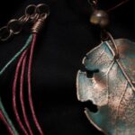 Завораживающее колье, в центре которого — подвеска в виде листа сирени, созданная с помощью техники гальванопластика. Лист словно хранит в себе историю: фактурные прожилки рассказывают о его жизни, а неровные, «объеденные» гусеницами края придают украшению особую, дикую прелесть, будто он только что был сорван в заросшем саду.