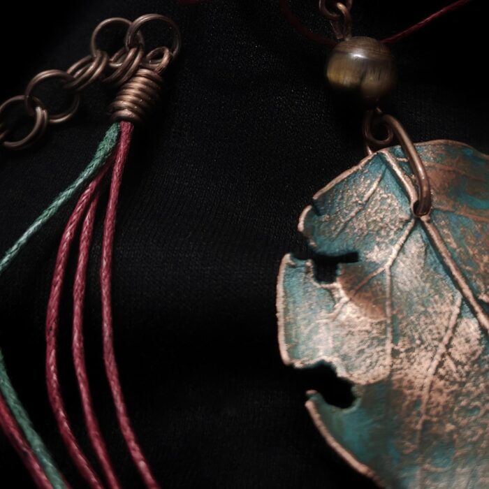 Завораживающее колье, в центре которого — подвеска в виде листа сирени, созданная с помощью техники гальванопластика. Лист словно хранит в себе историю: фактурные прожилки рассказывают о его жизни, а неровные, «объеденные» гусеницами края придают украшению особую, дикую прелесть, будто он только что был сорван в заросшем саду.