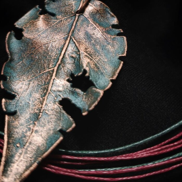 Завораживающее колье, в центре которого — подвеска в виде листа сирени, созданная с помощью техники гальванопластика. Лист словно хранит в себе историю: фактурные прожилки рассказывают о его жизни, а неровные, «объеденные» гусеницами края придают украшению особую, дикую прелесть, будто он только что был сорван в заросшем саду.