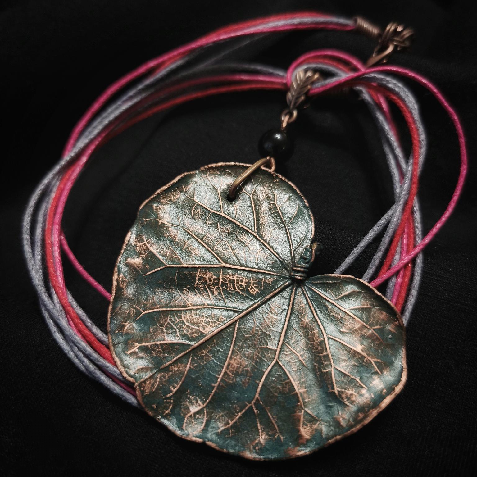 Изысканное колье, в центре которого — подвеска в виде листа скумпии, редкого растения-эндемика, произрастающего в Крыму. Лист, выполненный с помощью техники гальванопластика, поражает своей реалистичностью: каждая фактурная прожилка словно хранит в себе дыхание природы, её незримую энергию.