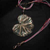 Изысканное колье, в центре которого — подвеска в виде листа скумпии, редкого растения-эндемика, произрастающего в Крыму. Лист, выполненный с помощью техники гальванопластика, поражает своей реалистичностью: каждая фактурная прожилка словно хранит в себе дыхание природы, её незримую энергию.