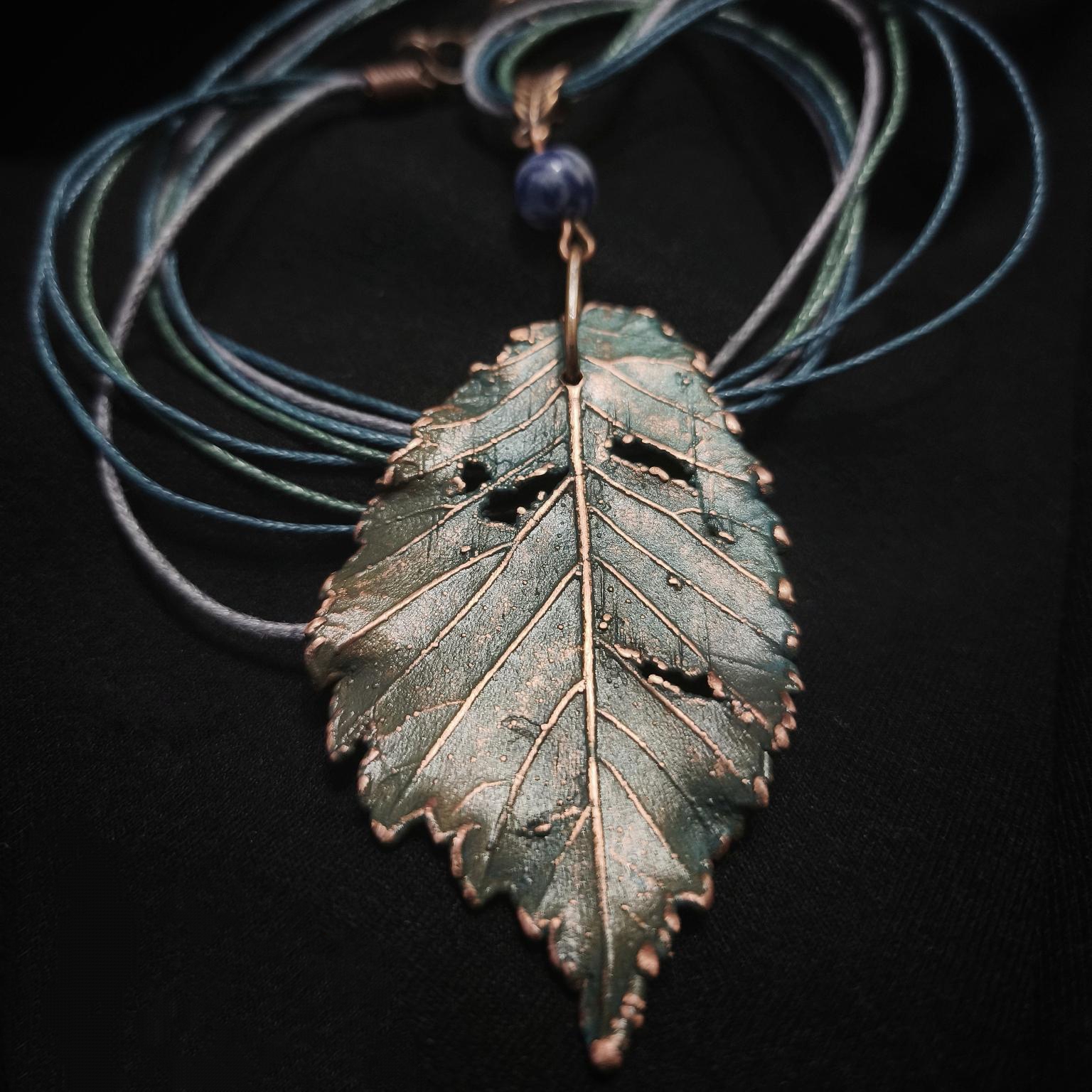 Утончённое колье, центральным элементом которого служит подвеска в виде листа Вяза, выполненная с помощью техники гальванопластика. Лист словно хранит в себе дыхание леса: его поверхность изобилует фактурными прожилками и природными дырочками, придающими украшению неповторимую естественность.