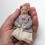 Кошечка Тина — нежная героиня серии «Крохотные истории». Теплая, спокойная, немного задумчивая — она словно хранит тихие домашние тайны. Создана вручную в Волшебной Мастерской с любовью к деталям и настроению.