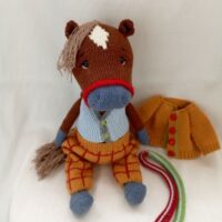 Вязаная игрушка — лошадка в стильном наряде Подарите себе или ребёнку частичку уюта и тепла с очаровательной вязаной игрушкой — лошадкой, выполненной с любовью и вниманием к деталям.