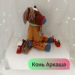 Вязаная игрушка — лошадка в стильном наряде
