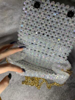 Представляем изысканную сумку из бусин, которая станет настоящим украшением вашего образа! Эта элегантная модель выполнена из прозрачных переливающихся бусин, создающих эффект мерцающего хрусталя. Благодаря тщательной ручной работе каждая бусина аккуратно закреплена, формируя цельную и прочную конструкцию.