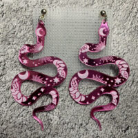 Представляем эффектные серьги в виде изящных змеек — смелое и стильное украшение для истинных ценительниц необычных аксессуаров! Эти серьги сразу привлекают внимание благодаря яркому дизайну и завораживающему сочетанию оттенков розового и фиолетового.