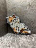 Представляем очаровательный брелок, выполненный в технике вышивки крестиком на пластиковой канве. Центральным элементом дизайна стал расслабленный котик в характерной «ленивой» позе — лежащий на боку с поднятой лапкой. Этот аксессуар сочетает в себе игривость и уют, станет стильным дополнением к ключам, рюкзаку или сумке.