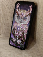 Элегантный футляр для очков, украшенный изысканной алмазной вышивкой с изображением совы, станет не только практичным аксессуаром, но и стильным элементом вашего образа. Центральным элементом дизайна является детализированное изображение совы, выполненное с использованием разноцветных страз и бусин — от нежно-розовых и перламутровых до насыщенных фиолетовых и золотистых оттенков.