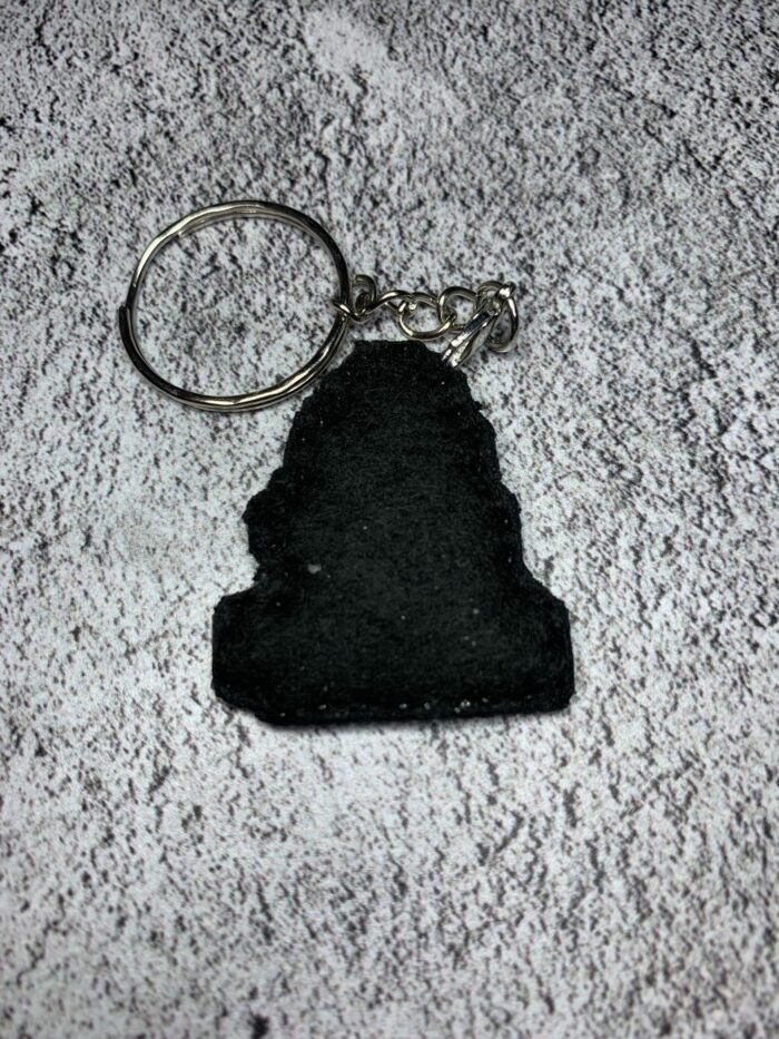 Представляем очаровательный брелок, выполненный в технике вышивки крестиком на пластиковой канве. Центральным элементом дизайна стал милый котик с расслабленным выражением мордочки, украшенный тремя ярко-жёлтыми цыплятами — один на голове и по одному с каждой стороны. Этот аксессуар сочетает в себе игривость и уют, станет стильным дополнением к ключам, рюкзаку или сумке.