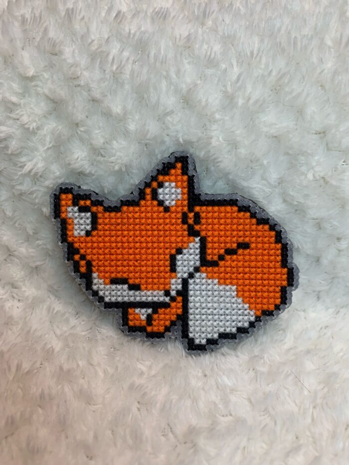 Представляем очаровательную брошь в виде спящей лисы, выполненную в стиле пиксель-арт — милый и стильный аксессуар для любителей животных и ретро-игр!