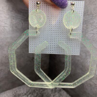 Представляем эффектные серьги с геометрическим дизайном — смелое украшение для тех, кто не боится выделяться! Эти крупные серьги выполнены из полупрозрачной акриловой смолы с мерцающими частицами, которые переливаются на свету, создавая волшебный голографический эффект.