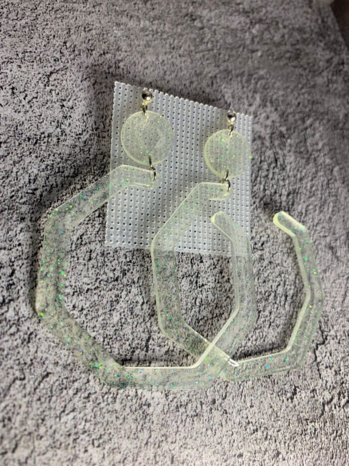 Представляем эффектные серьги с геометрическим дизайном — смелое украшение для тех, кто не боится выделяться! Эти крупные серьги выполнены из полупрозрачной акриловой смолы с мерцающими частицами, которые переливаются на свету, создавая волшебный голографический эффект.